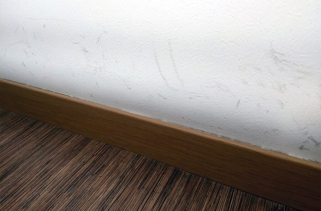 Scuff marks on an interior wall near the baseboard.